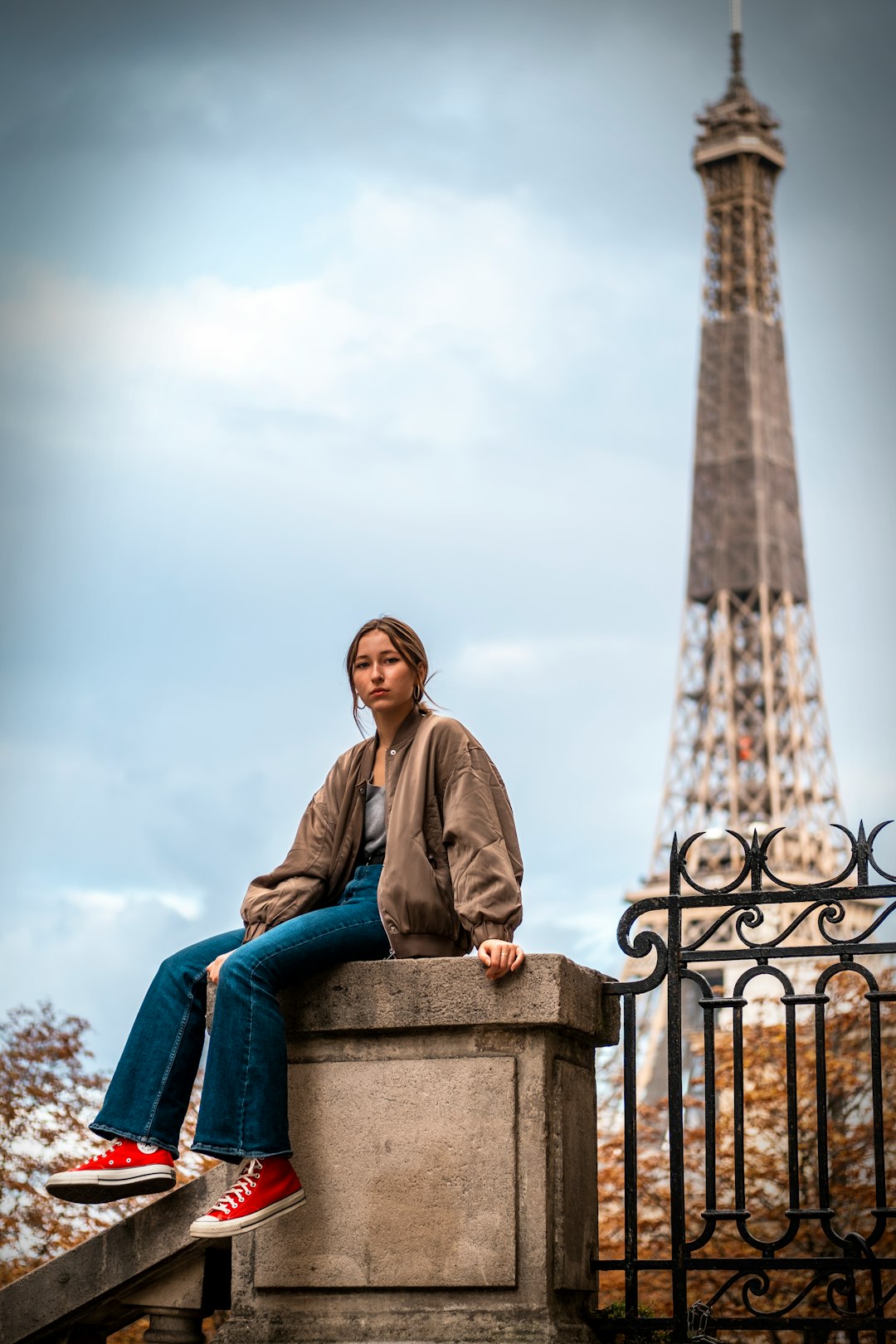 man in gray jacket sitting on blue concrete bench