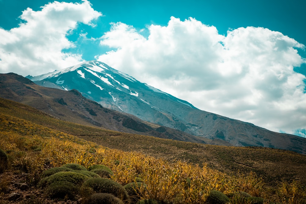 green and brown mountain under white clouds and blue sky during daytime