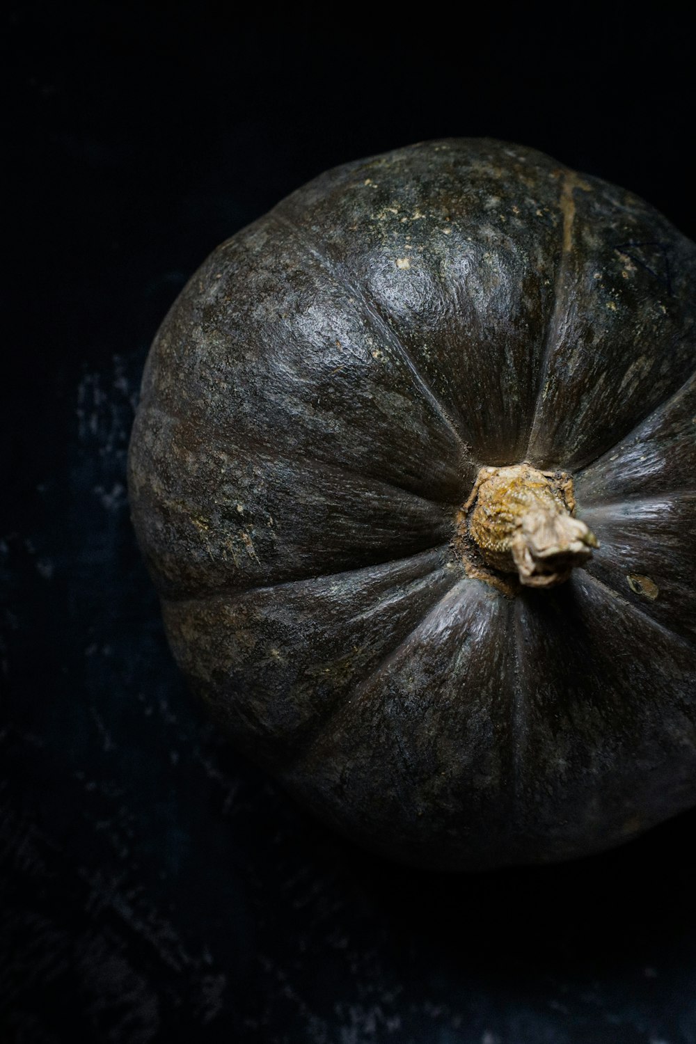 green and yellow pumpkin on black table