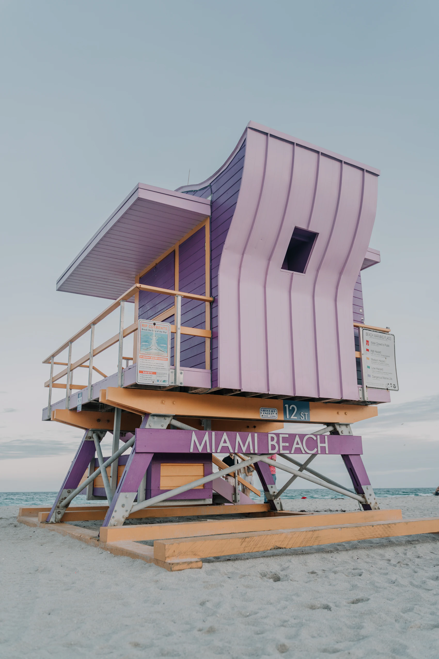A sculptural pastel lifeguard tower standing on Miami Beach beneath a pale sky