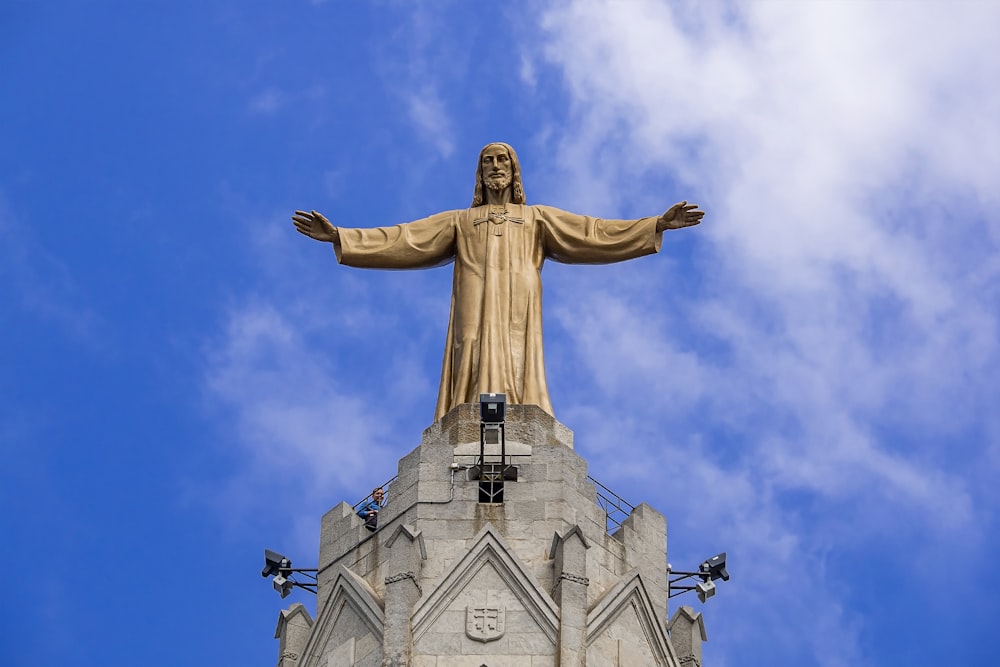 gold statue under blue sky