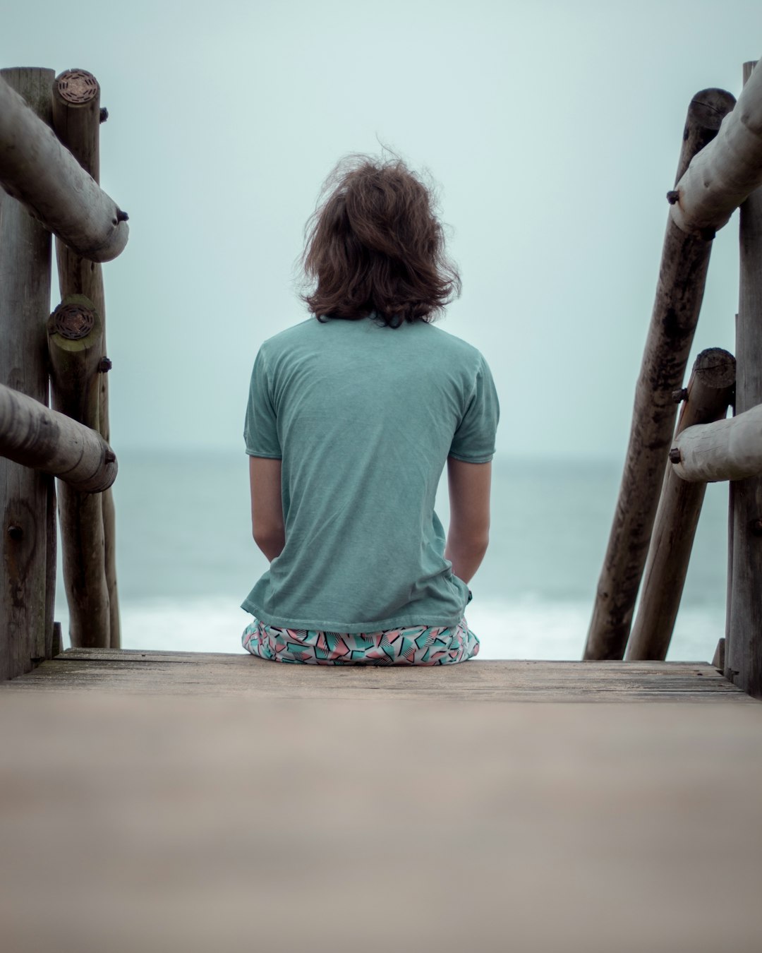 girl in green t-shirt standing on beach during daytime