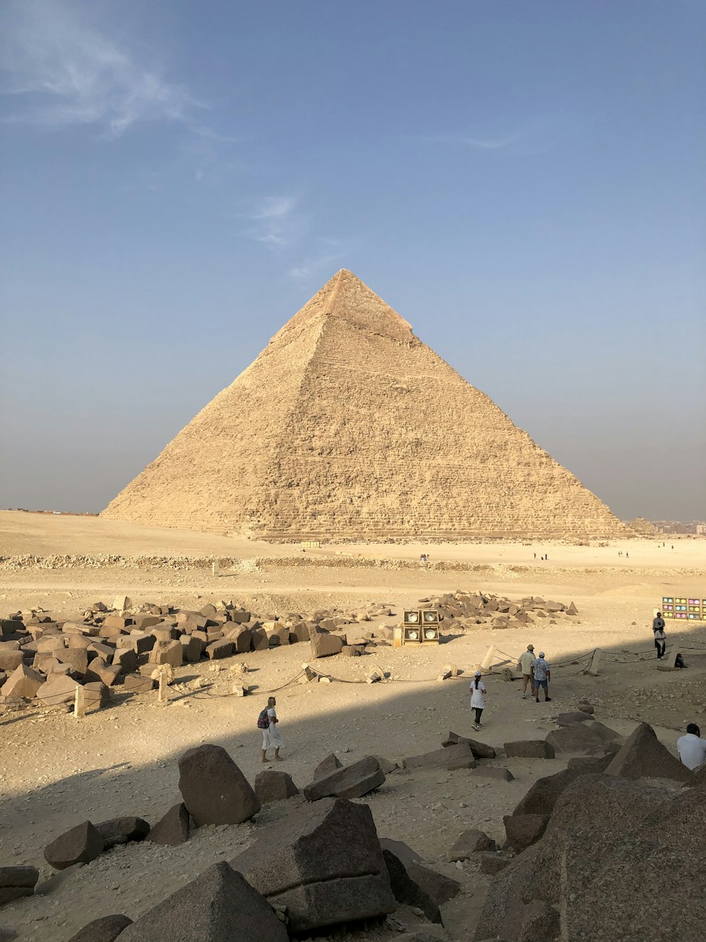 persone sulla sabbia marrone vicino alla piramide durante il giorno