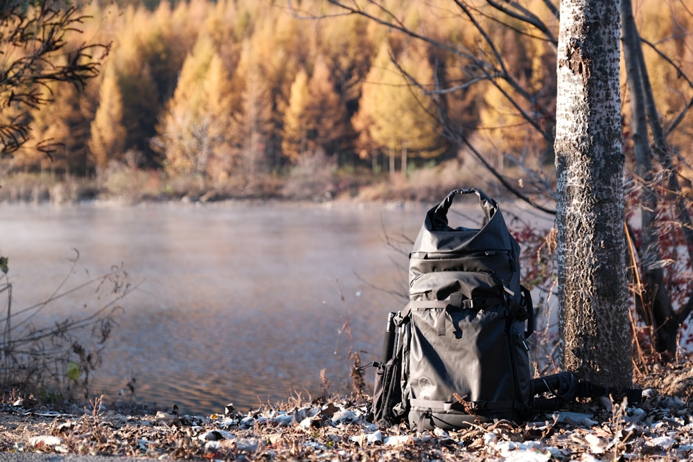 gray and black hiking backpack on rocky shore during daytime