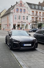 A stylish black car parked in front of a famous Parisian landmark.