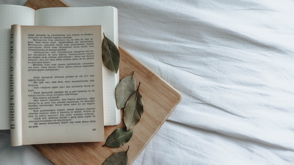 white and brown book on white textile