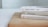 Three books are stacked on a wooden surface, with their spines partially visible. The names on the spines suggest they are foreign language books. Light colors dominate the scene, giving it a clean and minimalistic look.