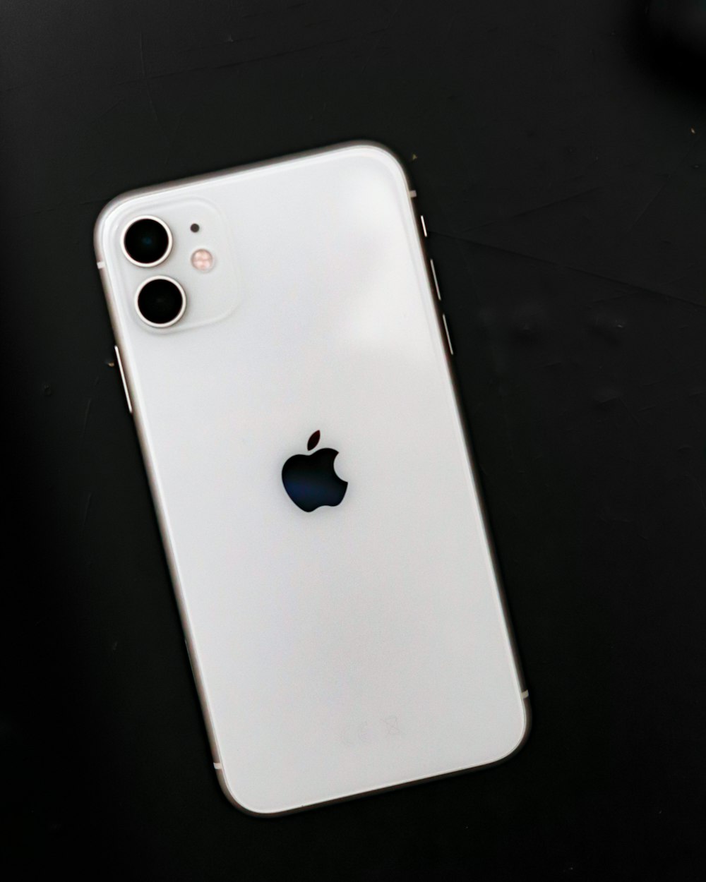 white iphone 5 c on black surface