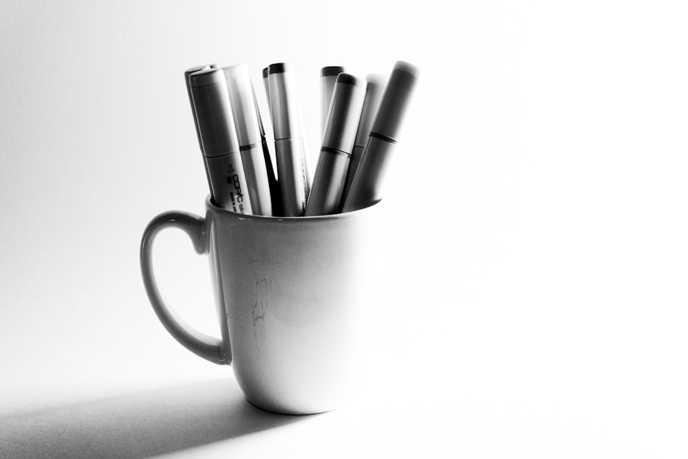 white ceramic mug with pen