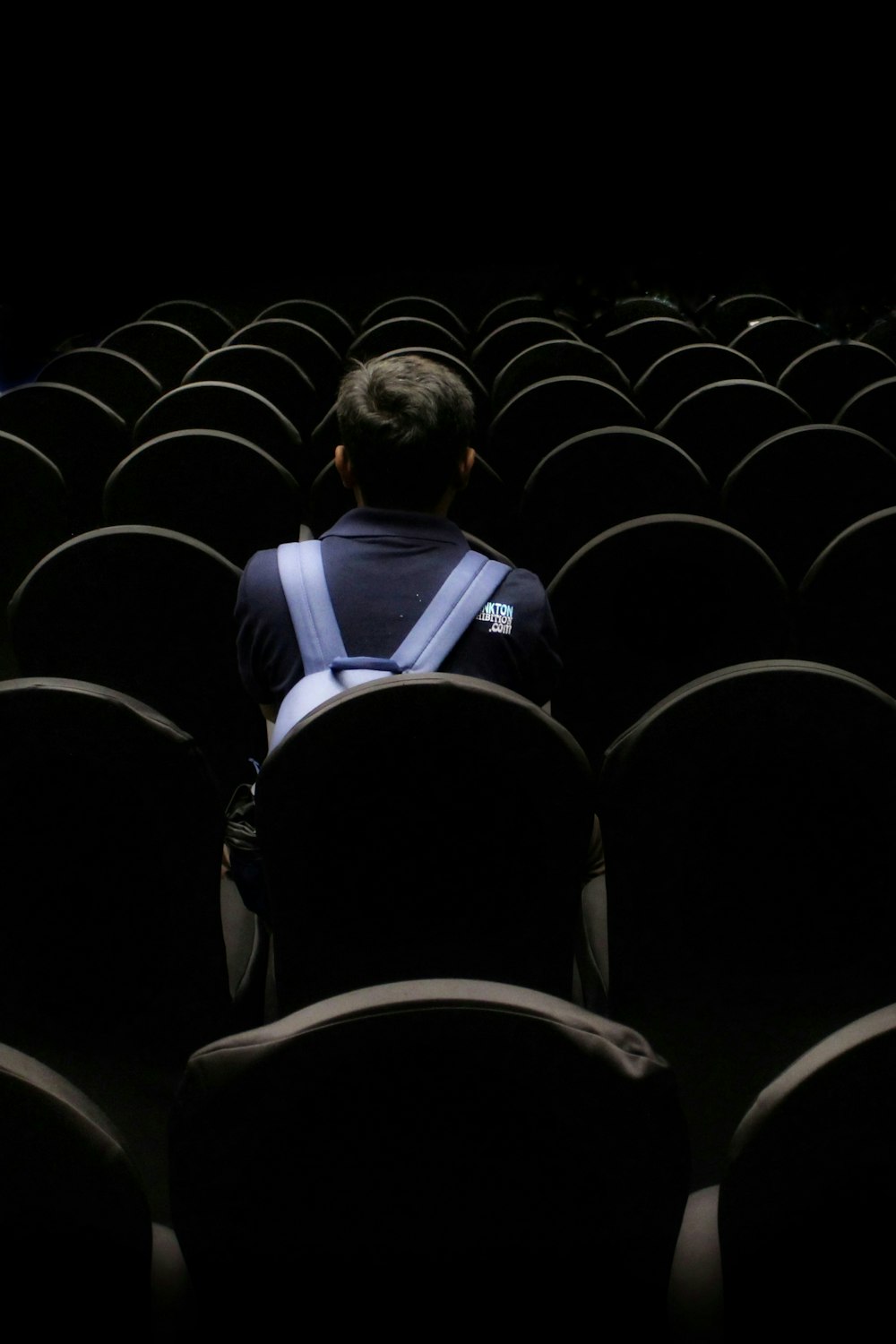 man in blue shirt sitting on black chair