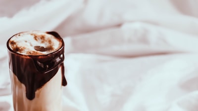 clear glass cup with brown liquid hot chocolate teams background