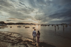 man and woman walking on beach during daytime