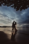 silhouette of couple walking on beach during sunset