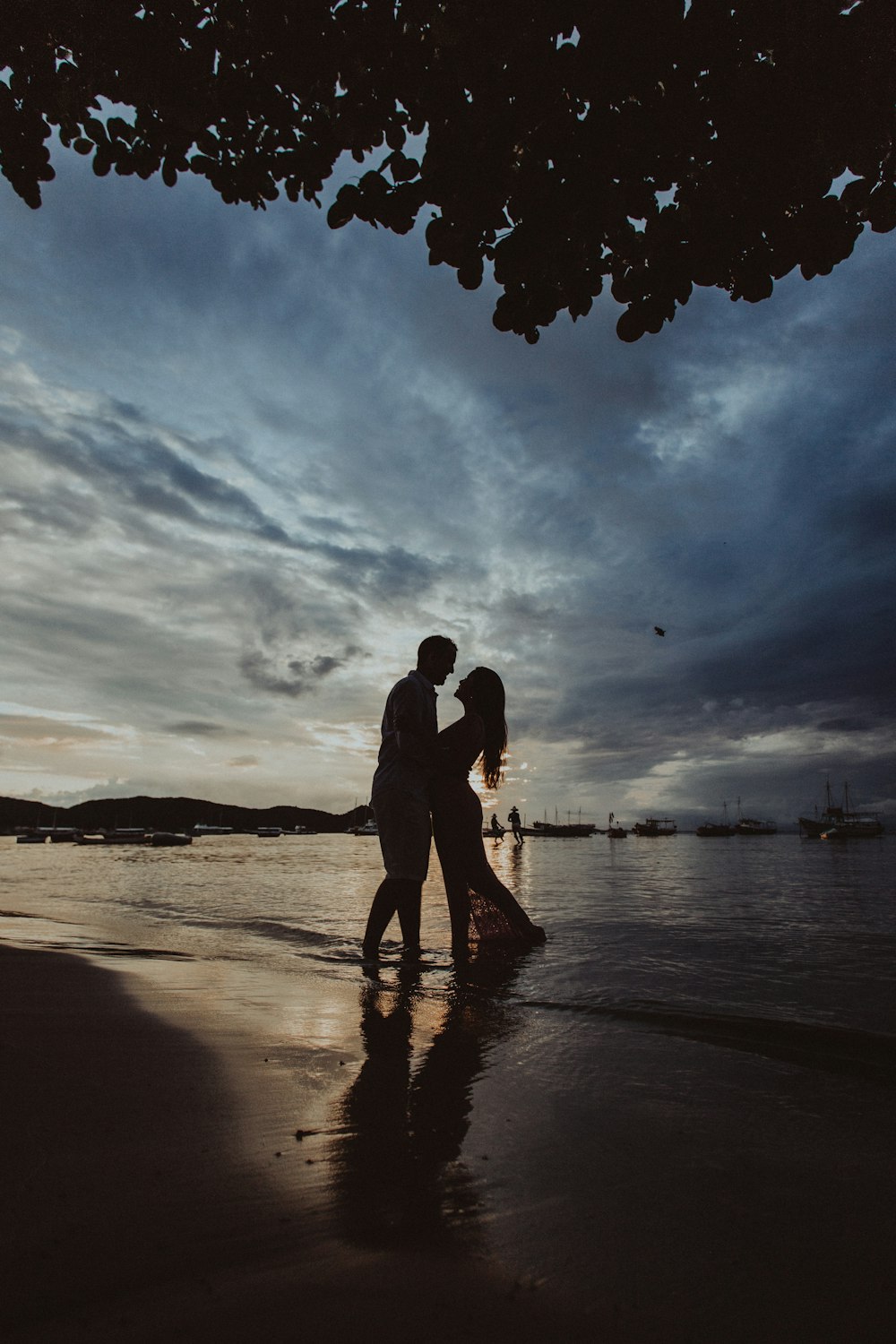silhouette di coppia che cammina sulla spiaggia durante il tramonto