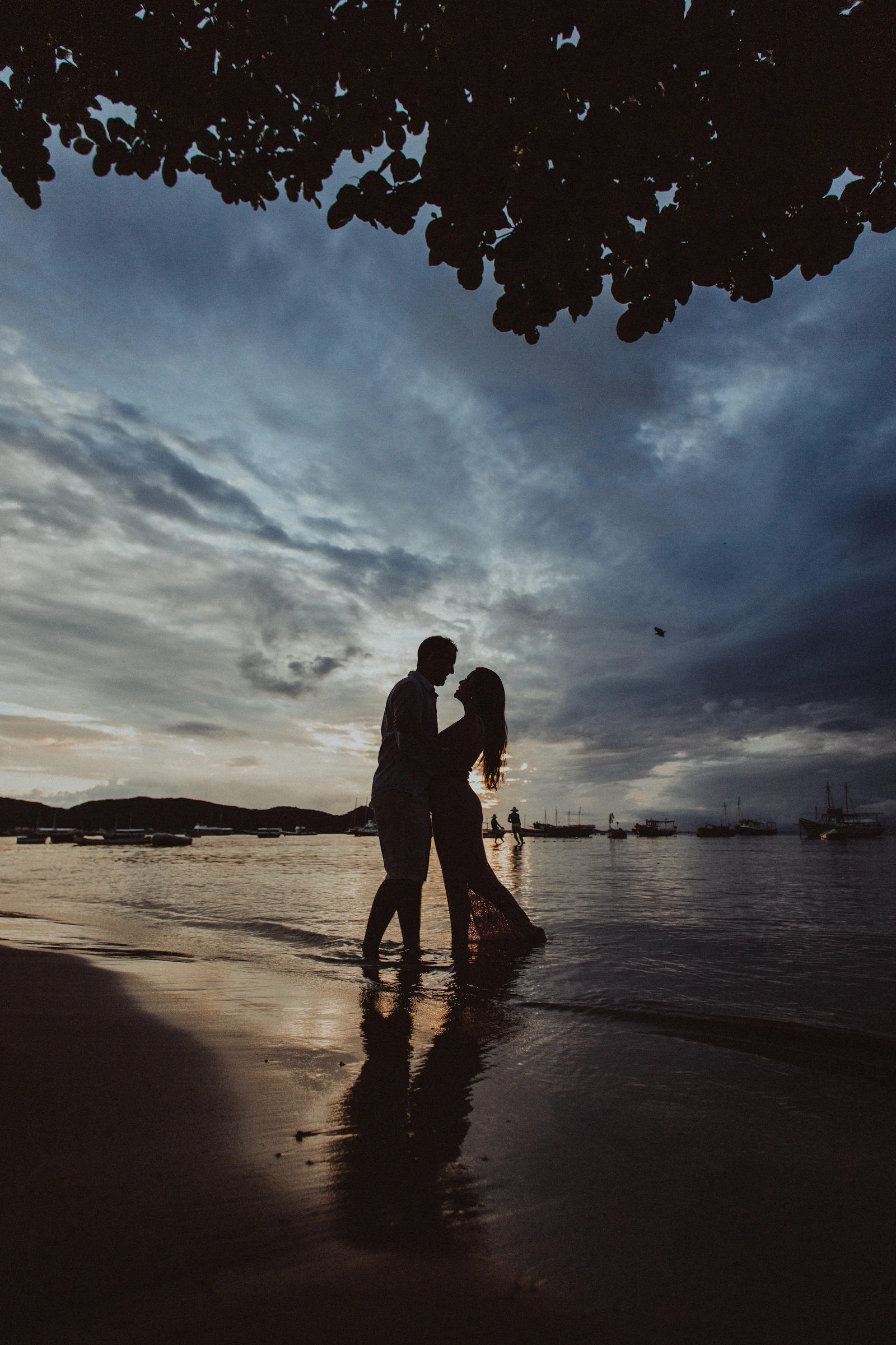 Silhouette of a couple walking together along the beach at sunset
