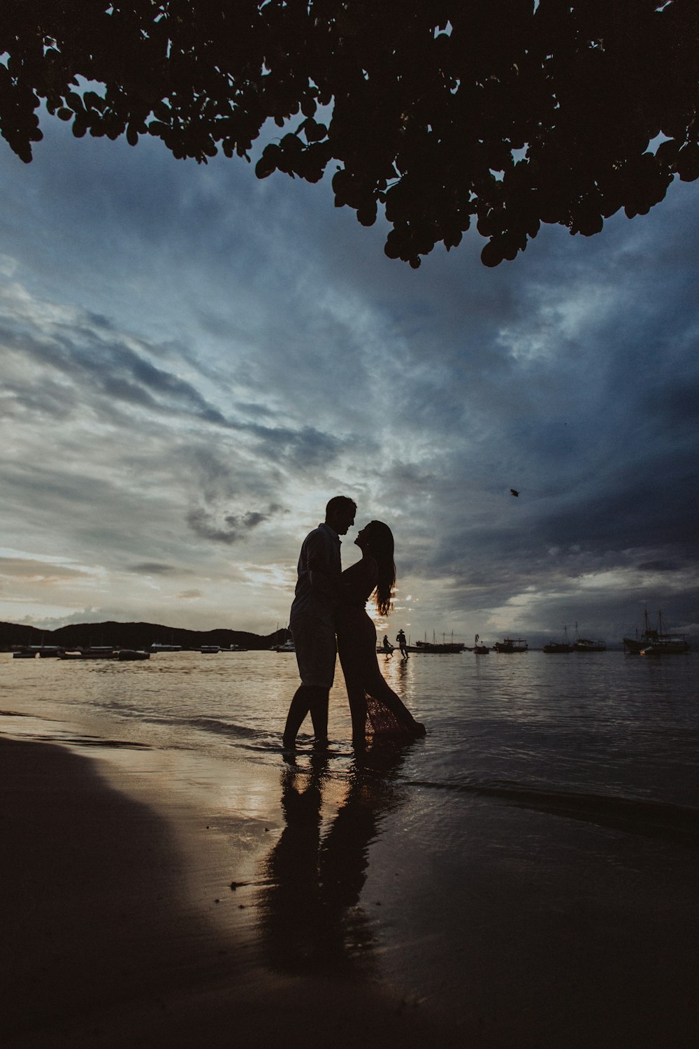 silhouette of couple walking on beach during sunset