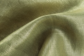 Close-up of luxurious fabric textures from Lumina Apparel under soft lighting.