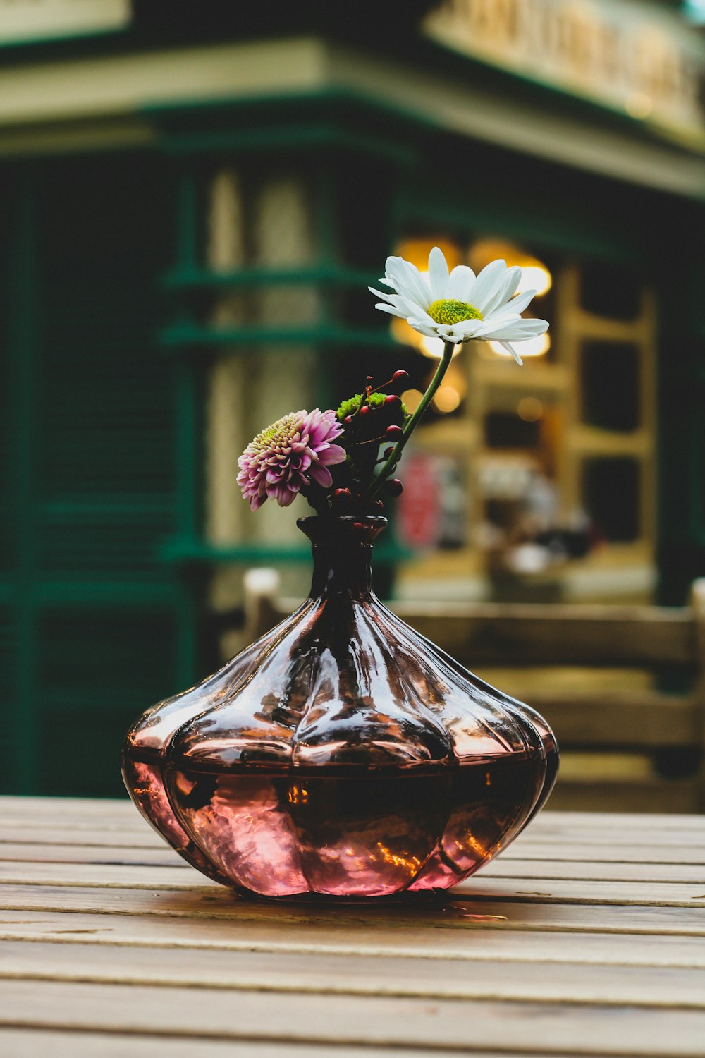 white and purple flowers in red glass vase