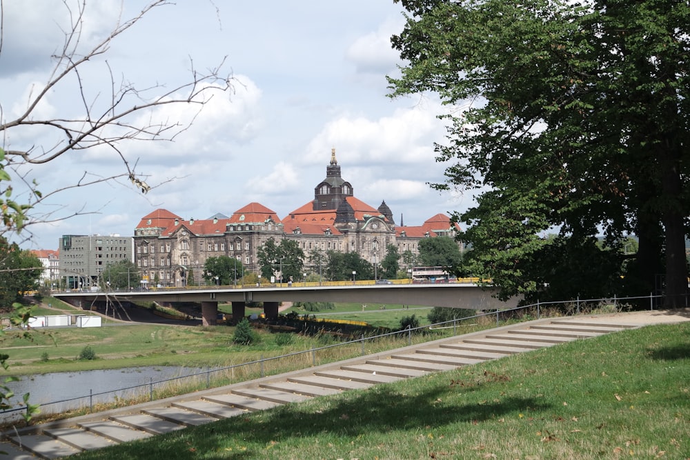 Braunes und weißes Betongebäude in der Nähe grüner Bäume unter weißen Wolken tagsüber