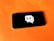 A smartphone rests on a bright orange surface. The screen displays a graphic of a white speech bubble with a wireless signal icon inside.