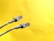 Two Ethernet cables with transparent connectors are positioned against a bright yellow background. The cables are light gray, with details visible in the wiring within the connectors.