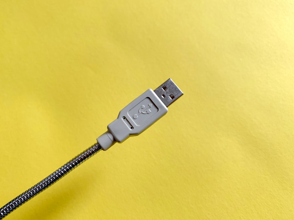 Cable USB blanco enchufado en una toma de corriente blanca