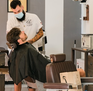 man in white t-shirt sitting on barber chair