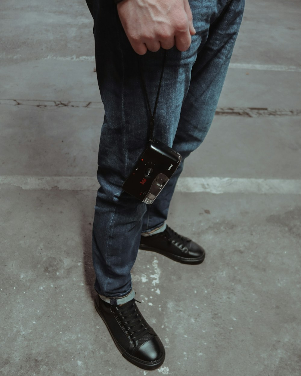 person in blue denim jeans and black leather boots