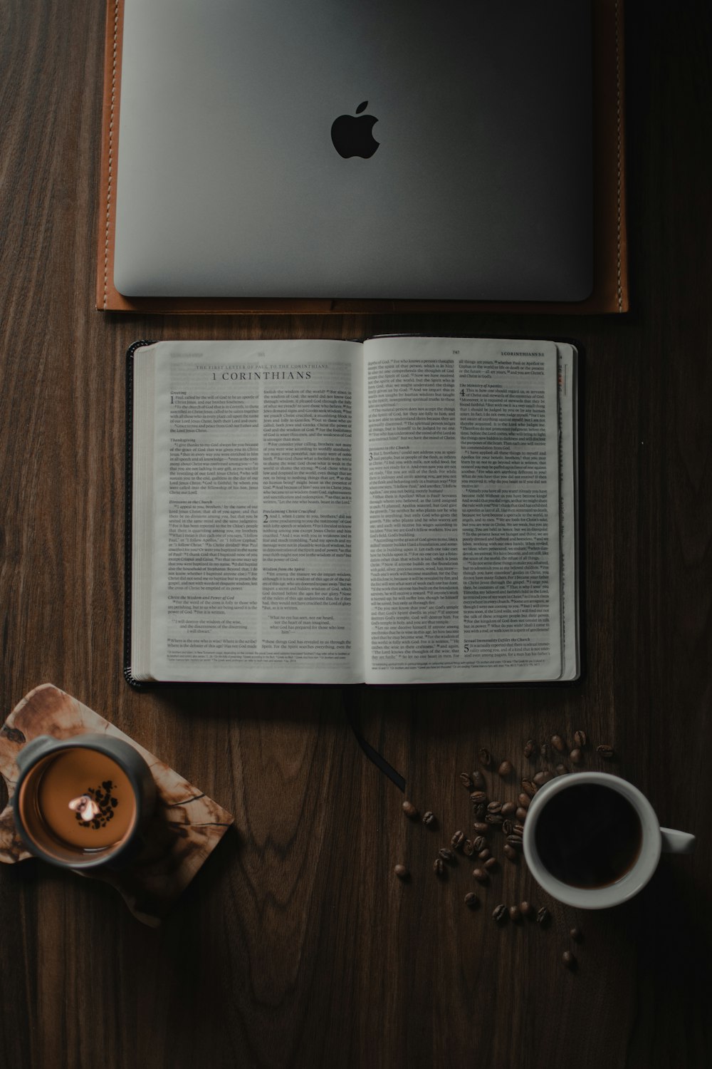 white book page beside white ceramic mug on brown wooden table