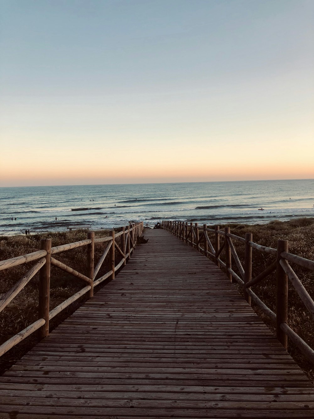 brown wooden dock on sea during sunset