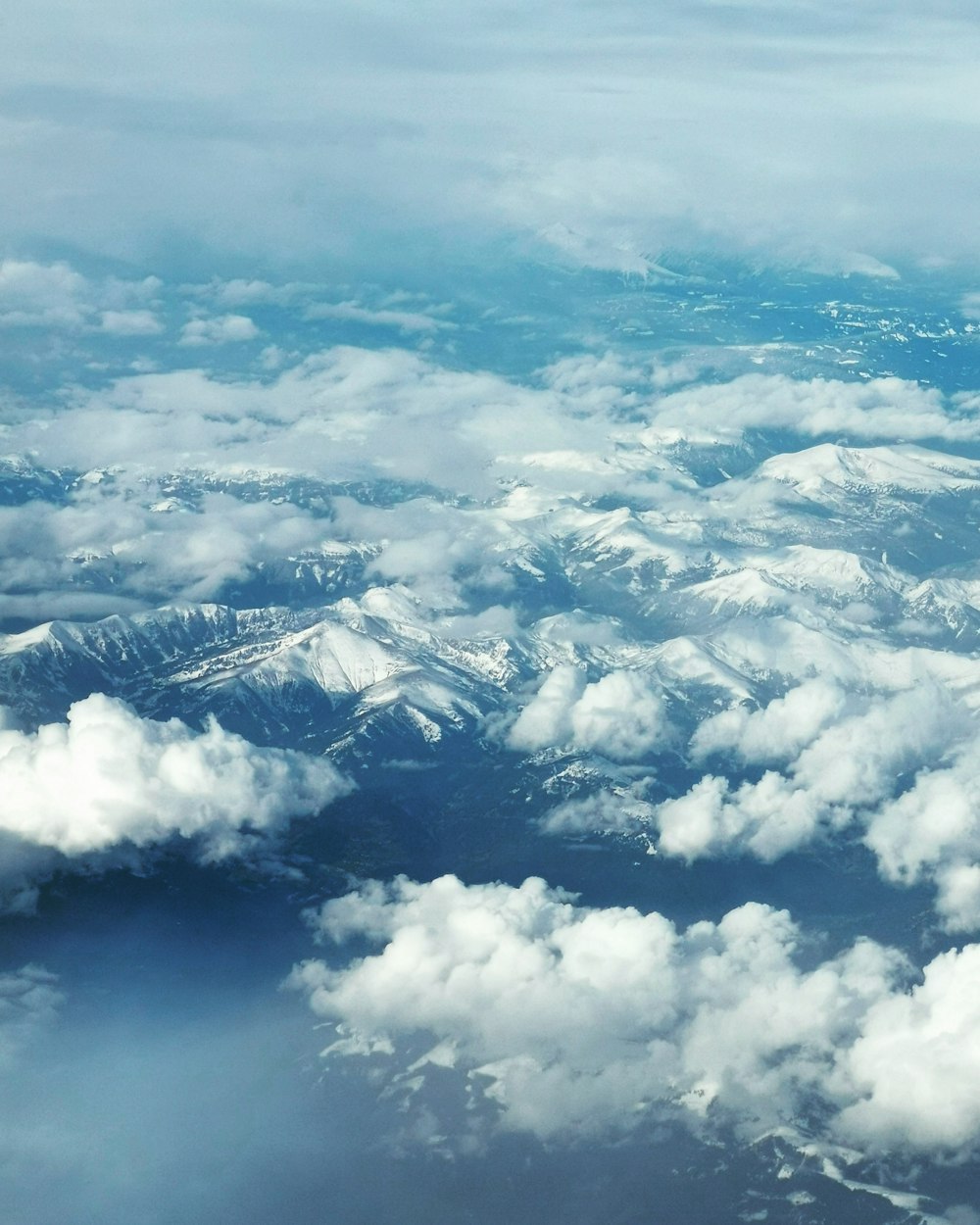 white clouds over snow covered mountains during daytime