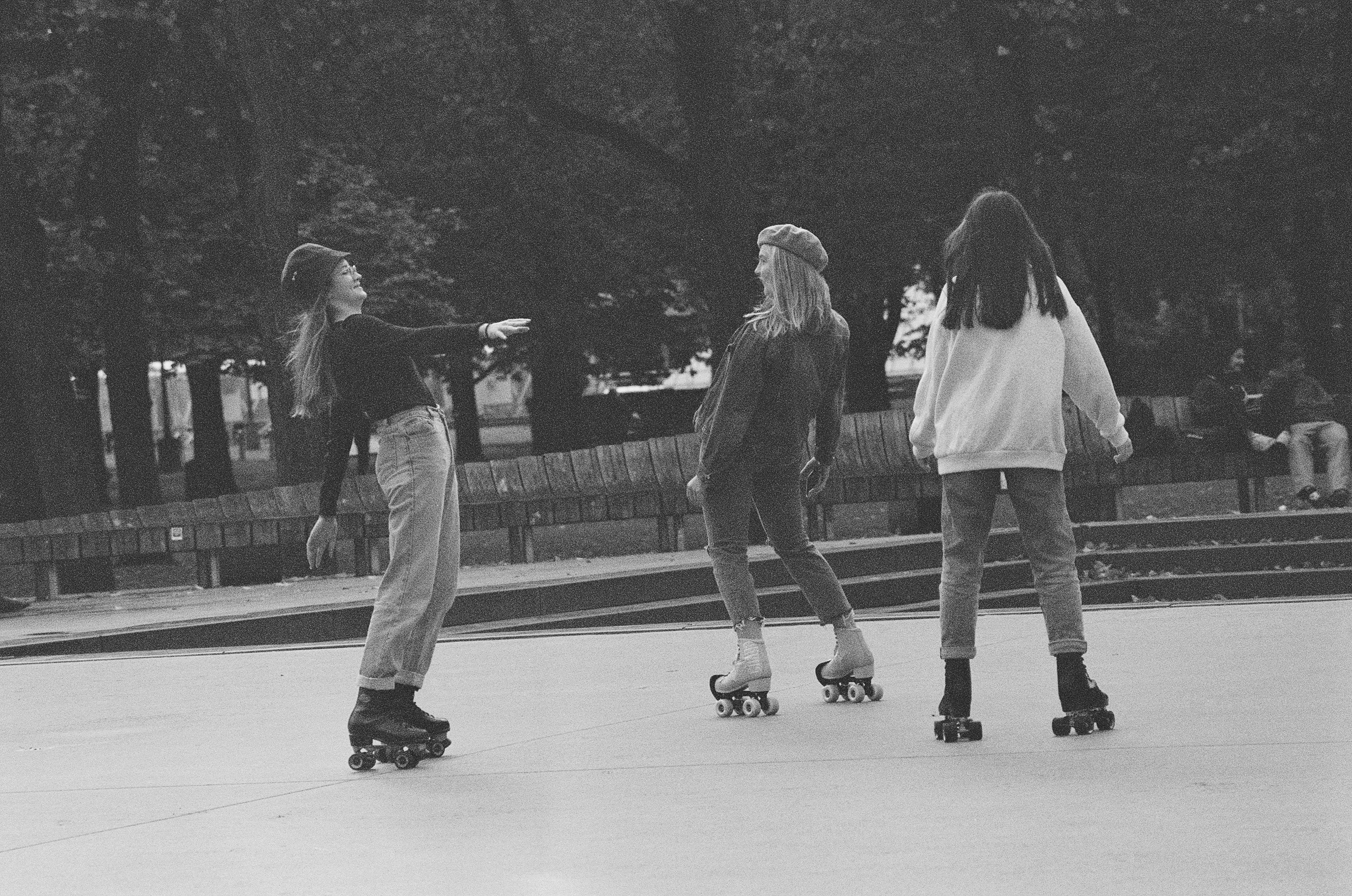 Black and white photo of three skaters rolling side by side