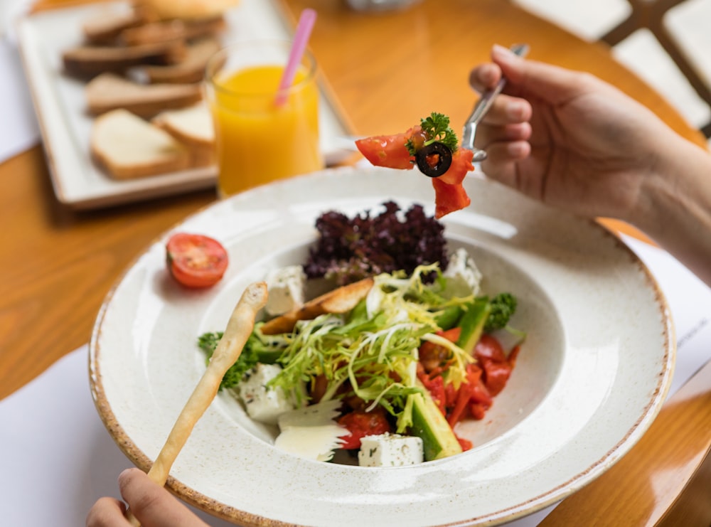 Ensalada de verduras en plato de cerámica blanca