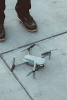 white quadcopter drone on floor