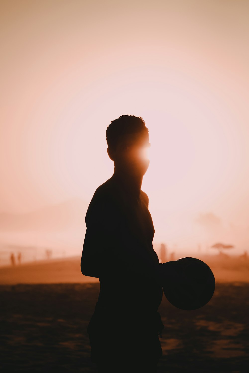 silhouette of man standing on field during sunset