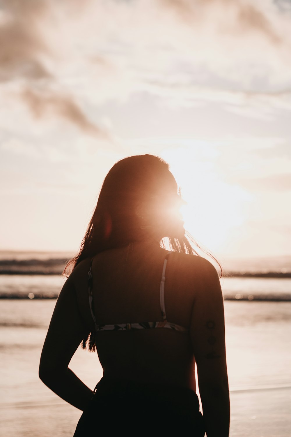 woman in black bikini standing on beach during daytime