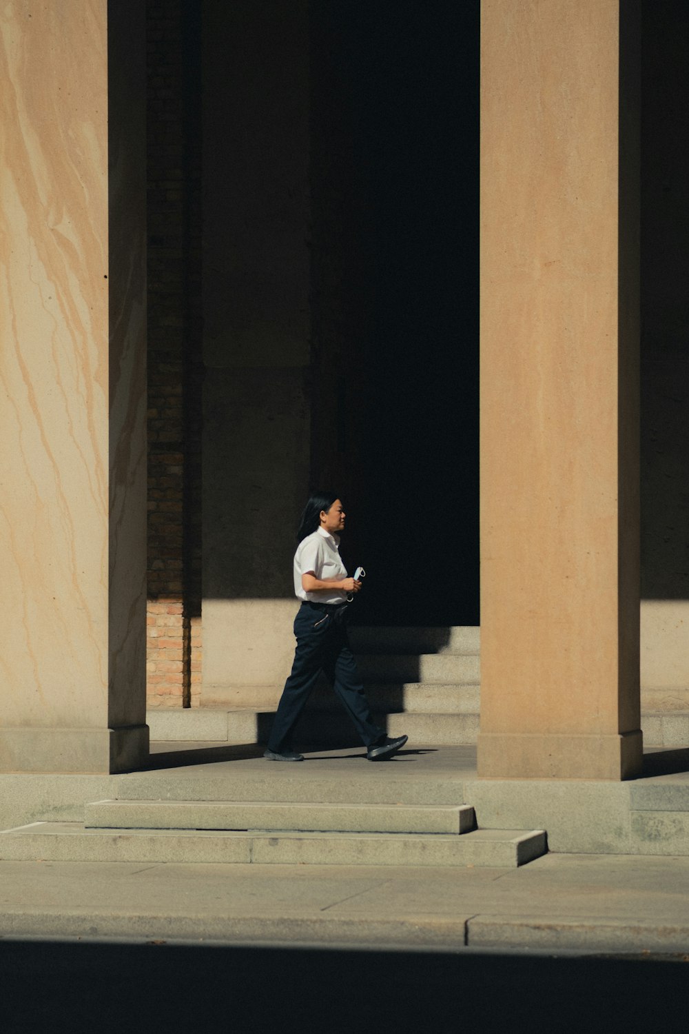 man in white dress shirt and black pants sitting on concrete bench