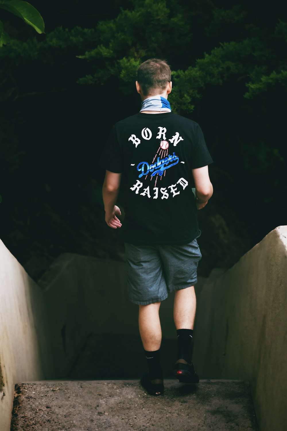 man in black crew neck t-shirt and blue shorts standing on stairs