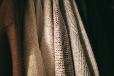 Close-up of soft fabric textures from various clothing items for men and women.