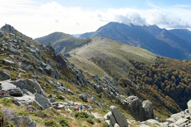 A group of trekkers walking along a mountain trail with panoramic views