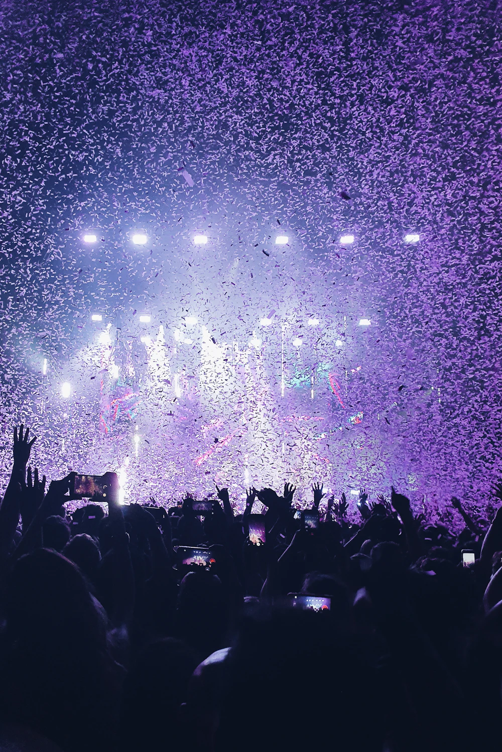 Multitud en un concierto con confeti cayendo sobre el público