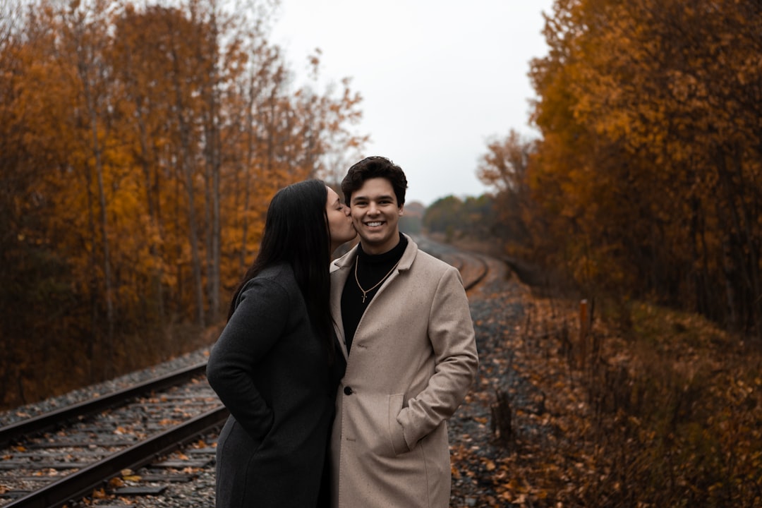 man in black jacket standing beside woman in brown coat