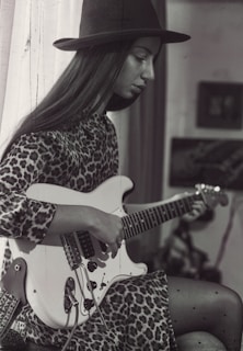 Leo il leone che suona la chitarra sotto un tendone colorato.