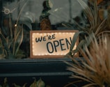 An open business sign in a welcoming storefront.
