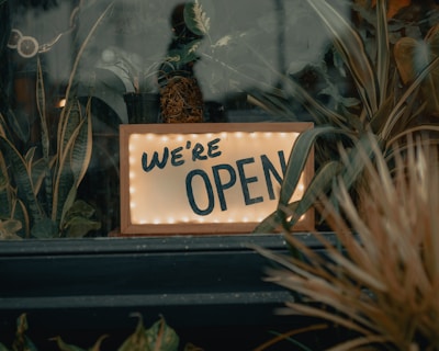 An open business sign in a welcoming storefront.