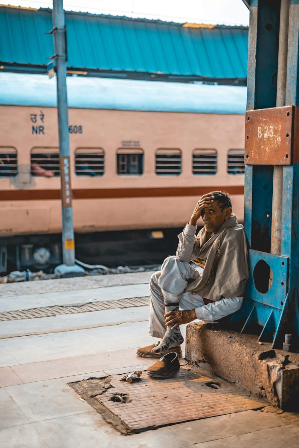 woman in white robe sitting on blue metal bench