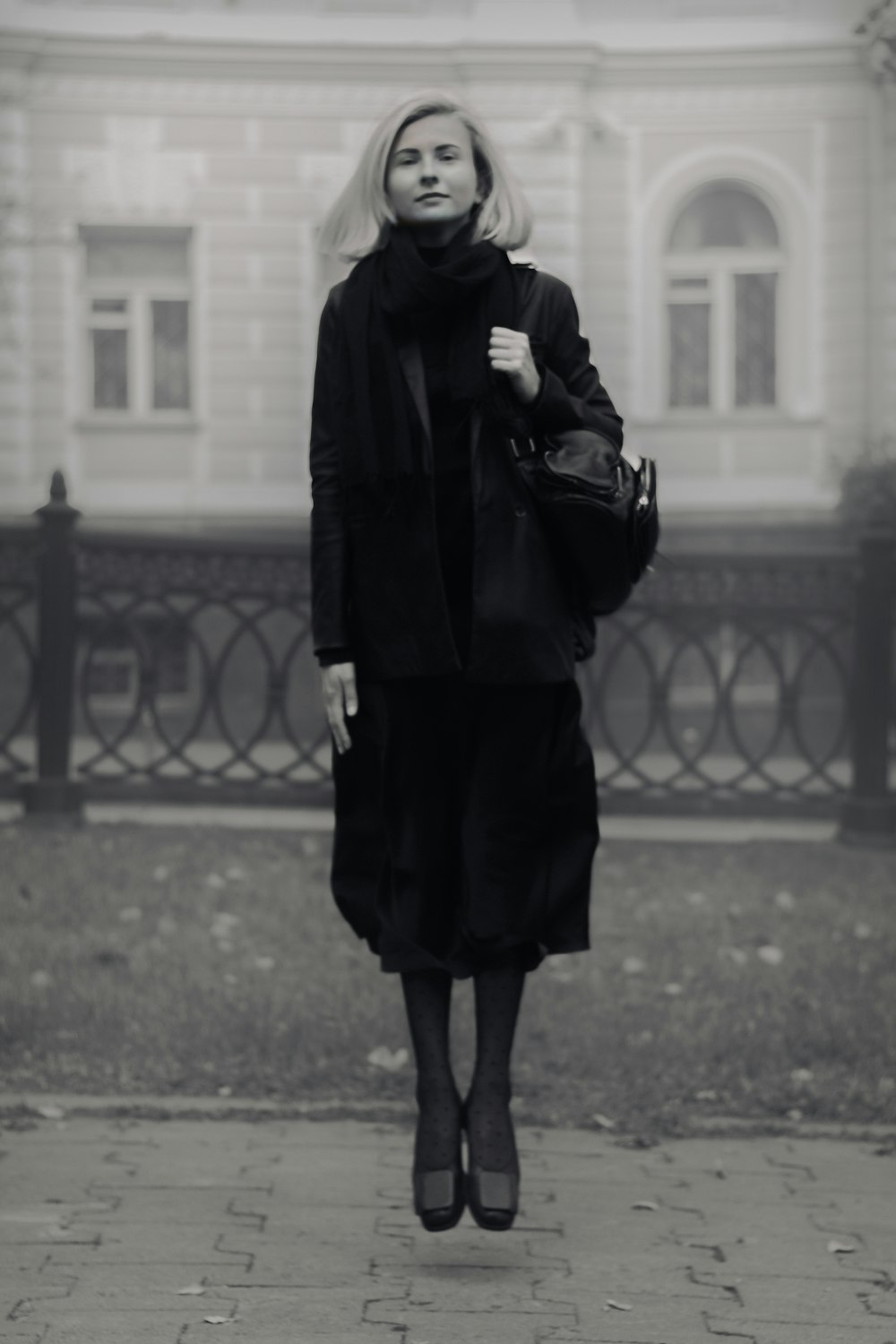 woman in black coat standing on road