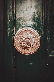 Elegant brass cabinet knobs with intricate detailing on wooden drawers.