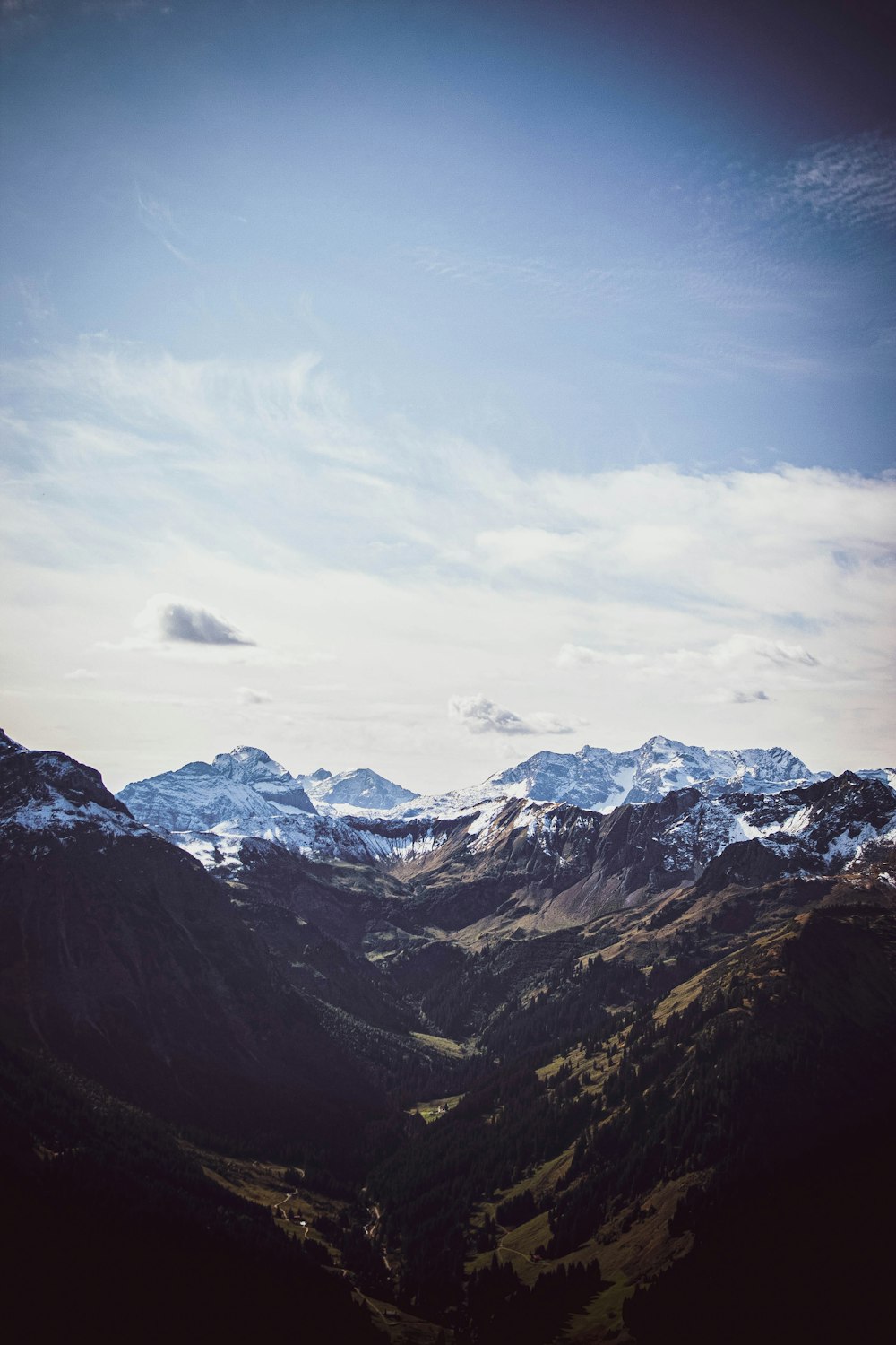 snow covered mountains under cloudy sky during daytime