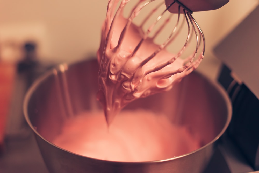 person pouring water on stainless steel bowl